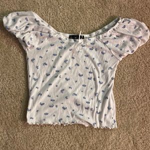 cute white cropped blue flower shirt. small and ruffled at the bottom.
